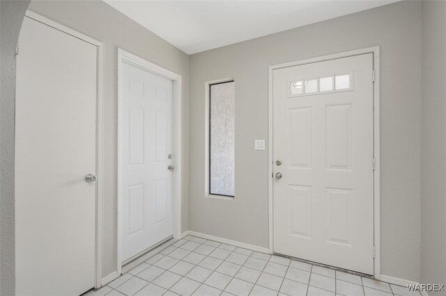 entryway with baseboards and light tile patterned flooring