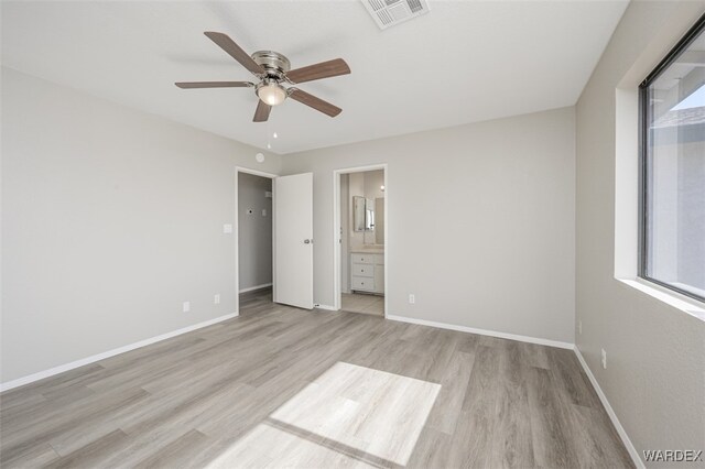 unfurnished bedroom featuring baseboards, visible vents, light wood-style flooring, and ensuite bathroom