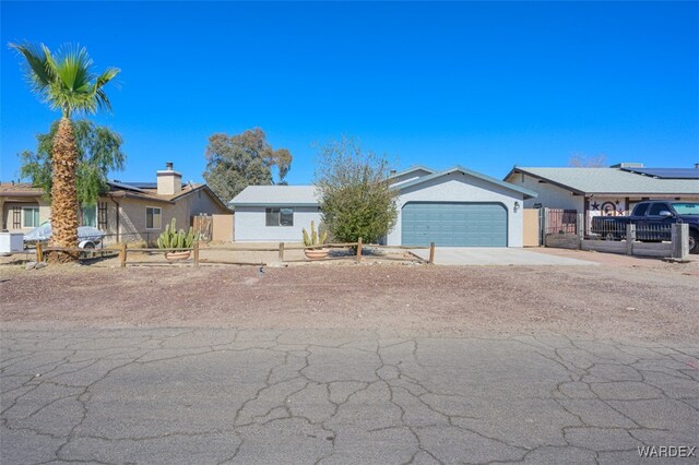 single story home featuring a fenced front yard, driveway, an attached garage, and stucco siding