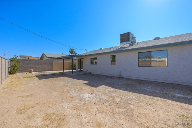 rear view of property with cooling unit, a patio area, a fenced backyard, and stucco siding