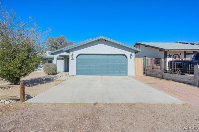 single story home featuring concrete driveway, an attached garage, fence, and stucco siding