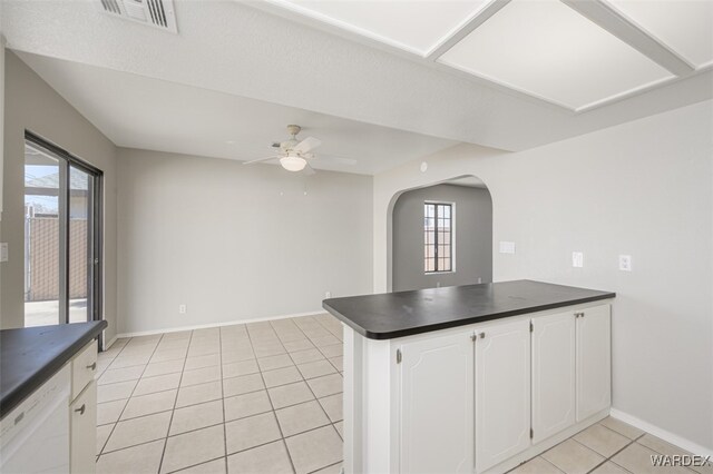 kitchen featuring dark countertops, visible vents, white cabinetry, white dishwasher, and a peninsula