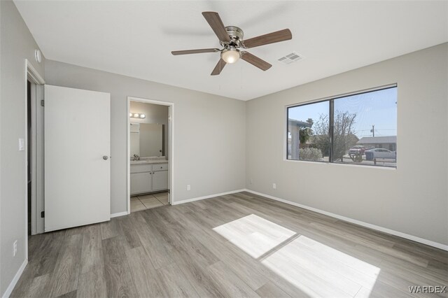 unfurnished bedroom with baseboards, visible vents, a ceiling fan, ensuite bathroom, and light wood-style floors