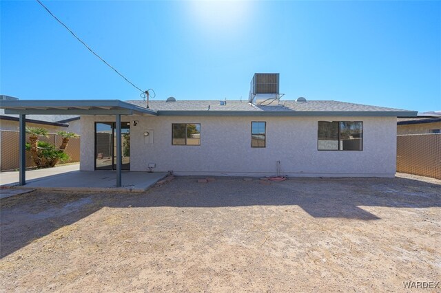 back of house featuring a patio, central AC, fence, and stucco siding