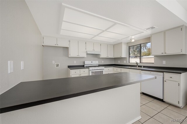 kitchen with dark countertops, white appliances, visible vents, and white cabinetry