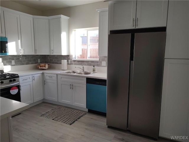 kitchen with appliances with stainless steel finishes, white cabinets, and light countertops