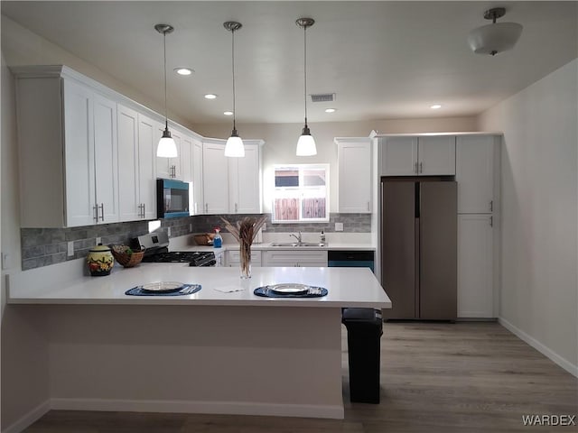 kitchen featuring light countertops, white cabinets, stainless steel range oven, and paneled fridge