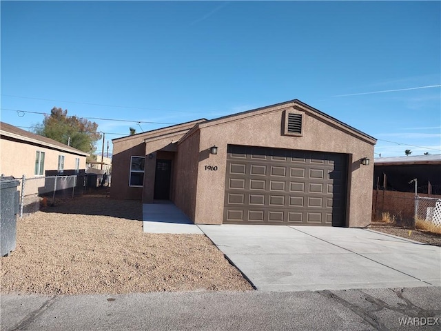 view of front of property featuring an attached garage, fence, concrete driveway, and stucco siding