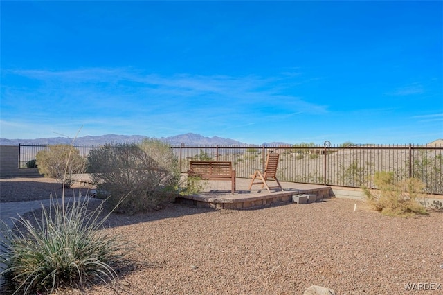 view of yard with a patio area, fence, and a mountain view