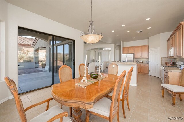 dining space with arched walkways, visible vents, recessed lighting, and light tile patterned floors