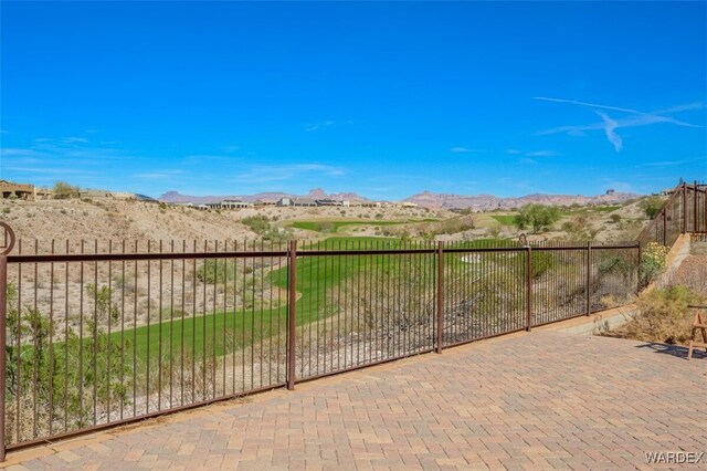 view of patio / terrace featuring fence and a mountain view