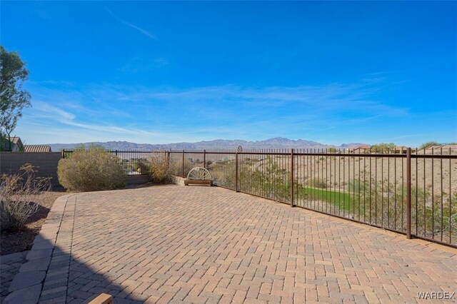 view of patio / terrace featuring fence and a mountain view