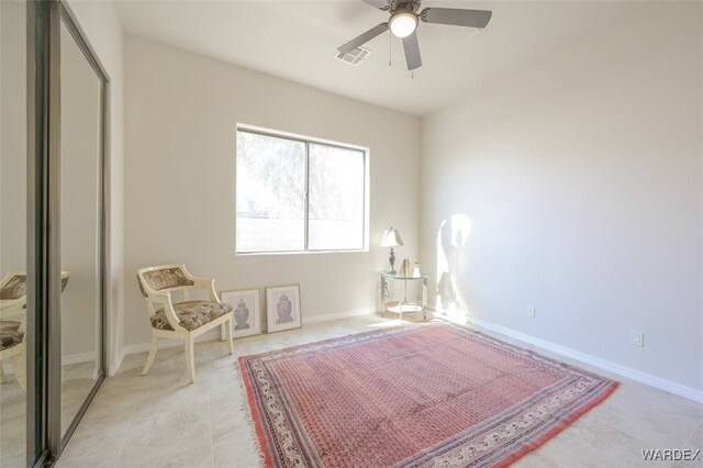 living area with light tile patterned floors, visible vents, baseboards, and ceiling fan