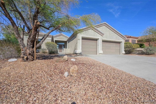 ranch-style home with a garage, concrete driveway, and stucco siding