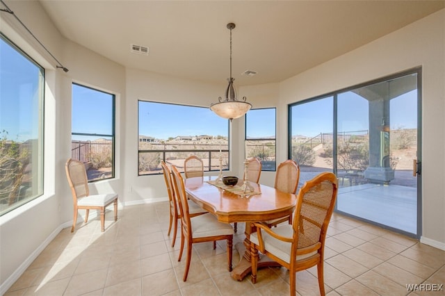 dining room featuring light tile patterned flooring, plenty of natural light, and visible vents