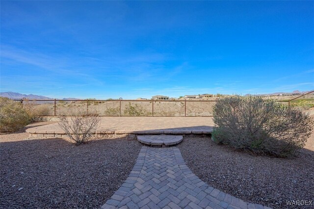 view of yard with a fenced backyard, a mountain view, and a patio