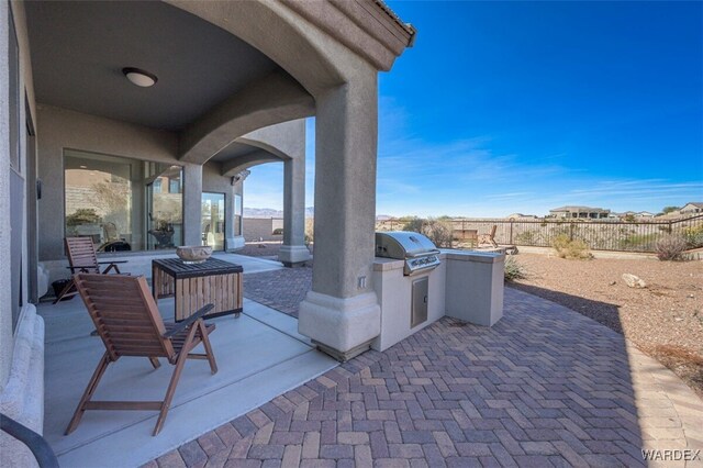 view of patio with a fenced backyard, a grill, and an outdoor kitchen