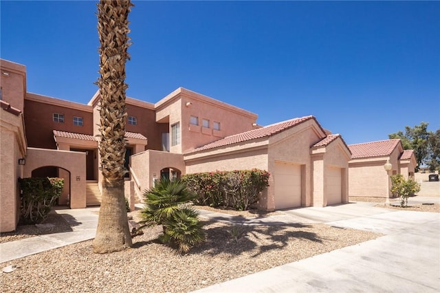 1650 Smoketree Ave Unit 103, Lake Havasu, AZ 86403 - view of front of property featuring a garage, stucco siding, driveway, and a tiled roof