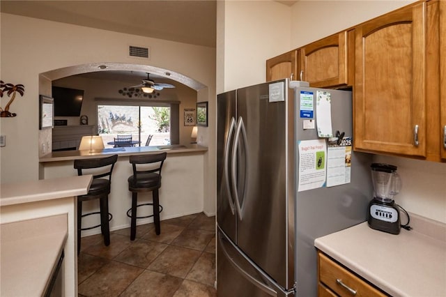 1650 Smoketree Ave Unit 103, Lake Havasu, AZ 86403 - kitchen with freestanding refrigerator, arched walkways, and brown cabinetry