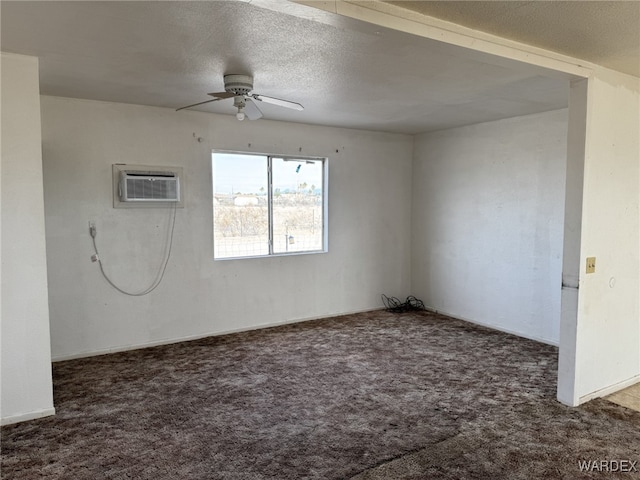 unfurnished room featuring a ceiling fan, a wall unit AC, dark carpet, and a textured ceiling