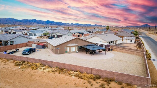 aerial view at dusk featuring a residential view and a mountain view