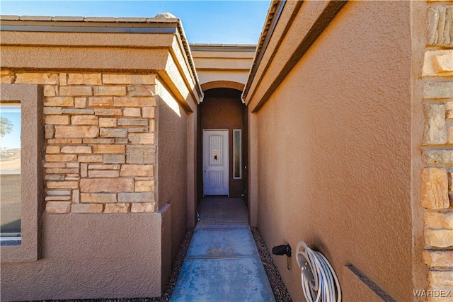 exterior space featuring stone siding and stucco siding