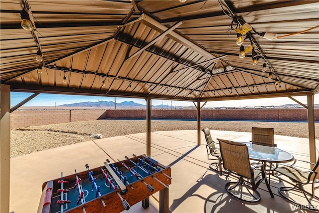 view of patio with fence, a gazebo, and a mountain view