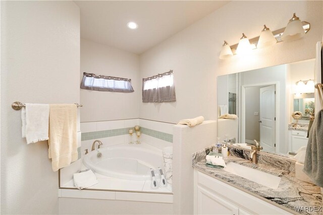 bathroom with a garden tub and vanity