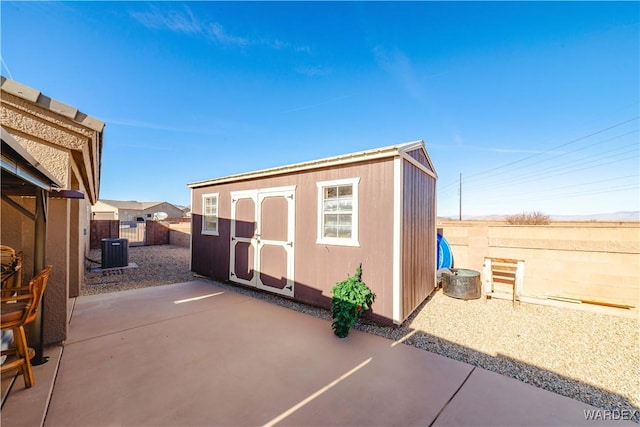 view of shed with central AC unit and a fenced backyard