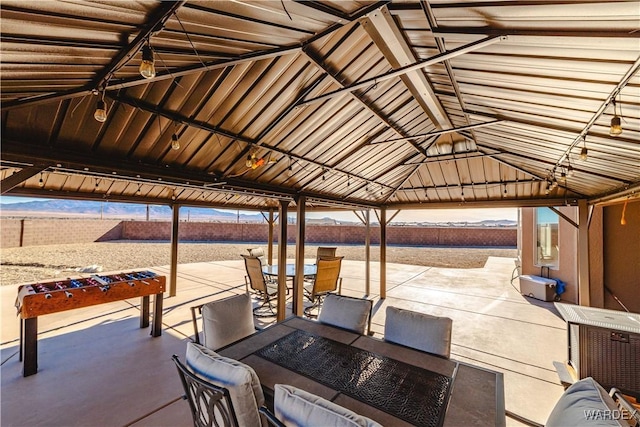 view of patio featuring a gazebo, an outdoor fire pit, outdoor dining area, and fence