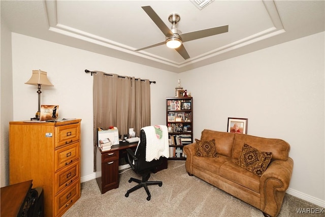 office featuring baseboards, a tray ceiling, a ceiling fan, and light colored carpet