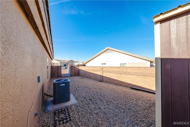 view of yard featuring a gate, central AC, and a fenced backyard