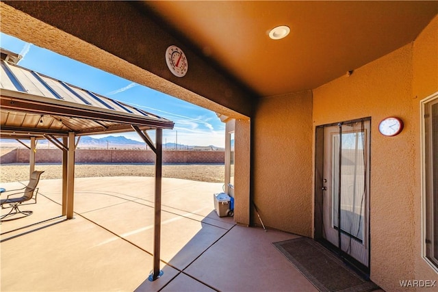 view of patio / terrace featuring fence and a mountain view