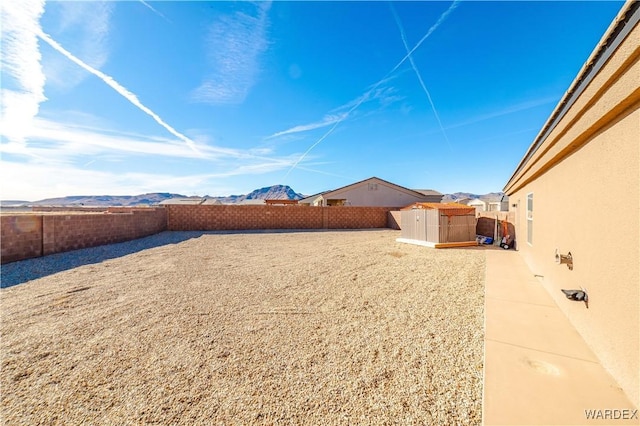 view of yard featuring a fenced backyard and a mountain view