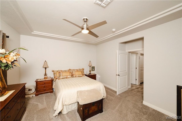 bedroom featuring a raised ceiling, light colored carpet, visible vents, ceiling fan, and baseboards