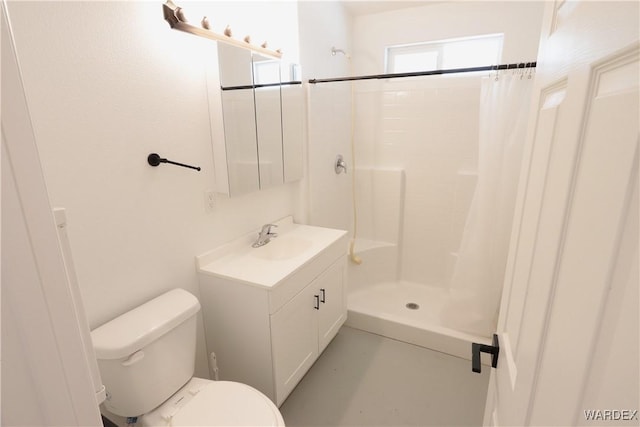 full bathroom featuring a stall shower, vanity, and toilet