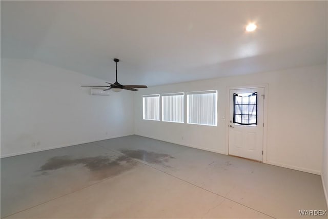 empty room featuring lofted ceiling, concrete floors, and a ceiling fan