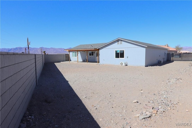 back of property with a fenced backyard and a mountain view