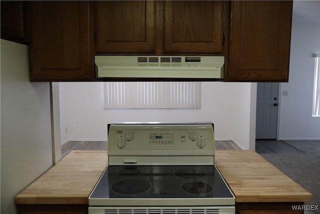 kitchen with extractor fan, dark brown cabinetry, butcher block counters, range with electric cooktop, and baseboards