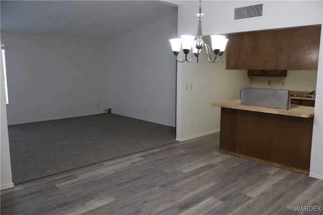 kitchen featuring an inviting chandelier, visible vents, wood finished floors, and decorative light fixtures