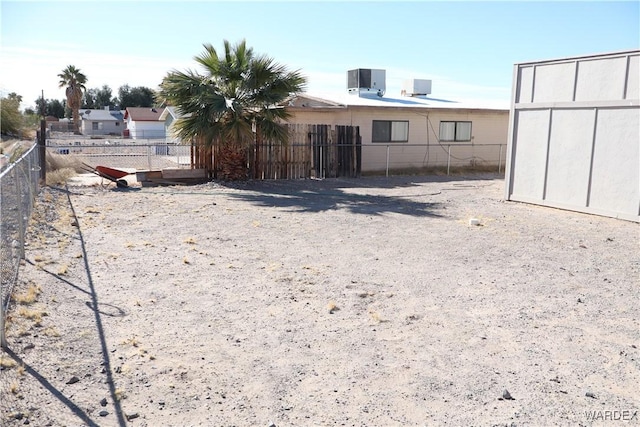 rear view of house featuring fence and central AC unit