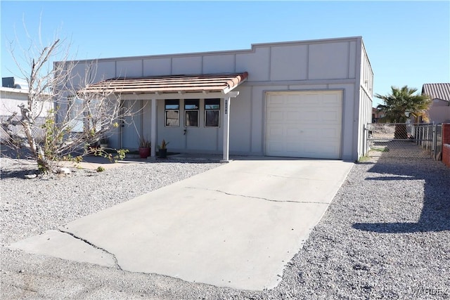 view of front of house featuring a garage, fence, and concrete driveway