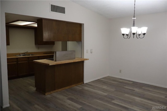 kitchen with visible vents, dark wood-style floors, butcher block counters, pendant lighting, and a sink