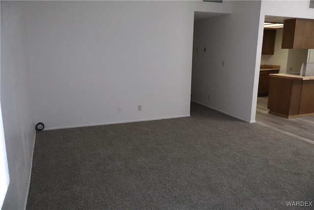 interior space with baseboards and dark colored carpet