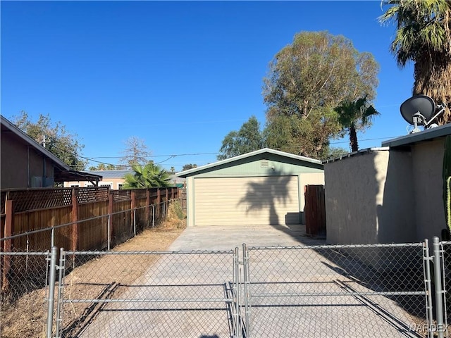 view of side of home with a garage, an outdoor structure, and fence