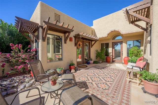 back of property with a patio area, a pergola, and stucco siding