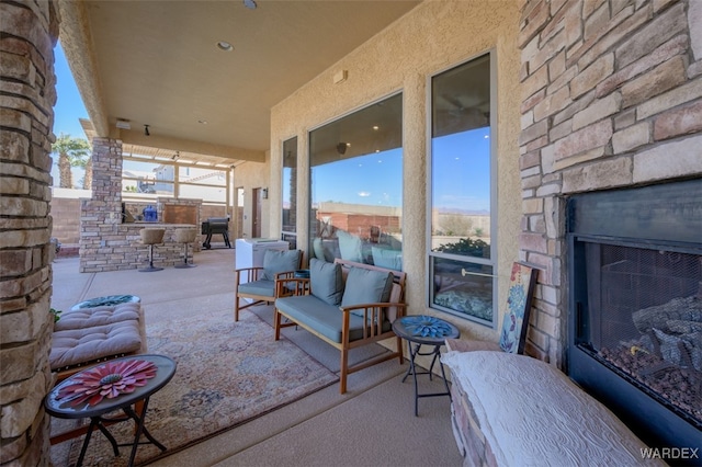 view of patio / terrace featuring an outdoor stone fireplace