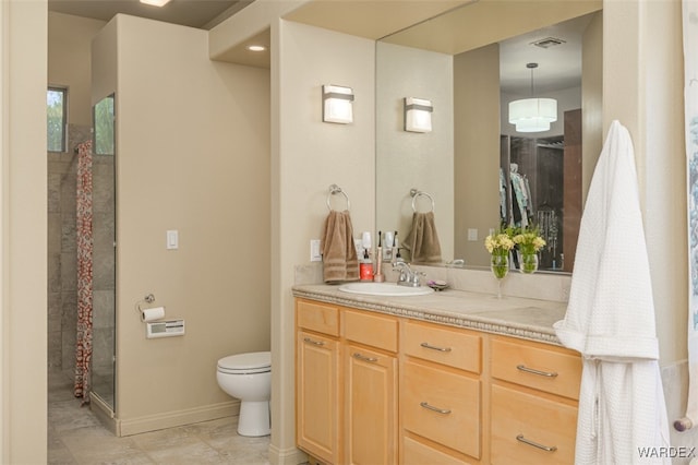 bathroom with visible vents, toilet, vanity, baseboards, and walk in shower