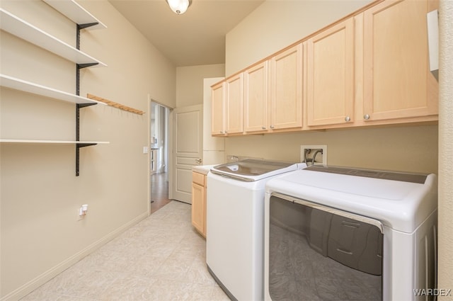 washroom with cabinet space, baseboards, and washer and dryer