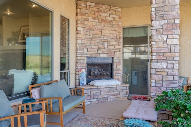 exterior space featuring stone siding, an outdoor stone fireplace, brick siding, and a patio